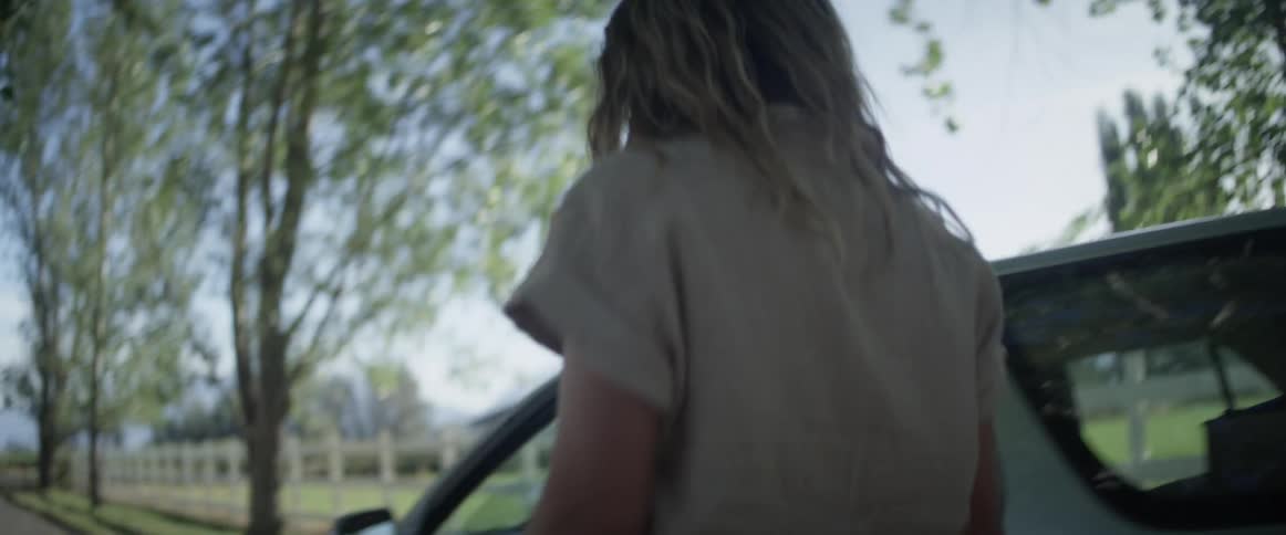 A mother and daughter hug before the daughter gets into a car