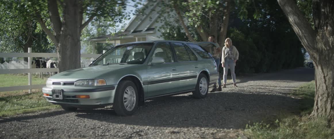 Young woman closes trunk of car and hugs her mother goodbye