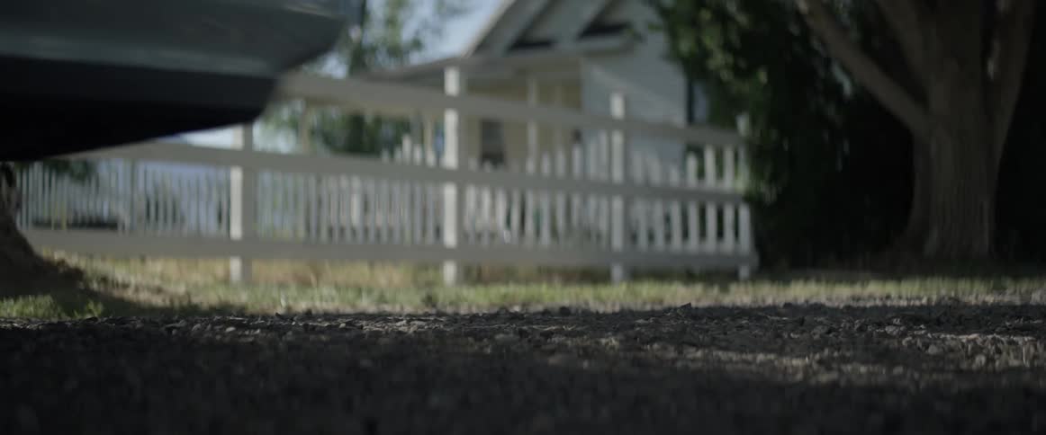 A car drives away from a house