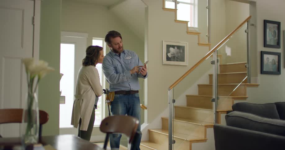 An employee of a home company speaks to a female client in her home
