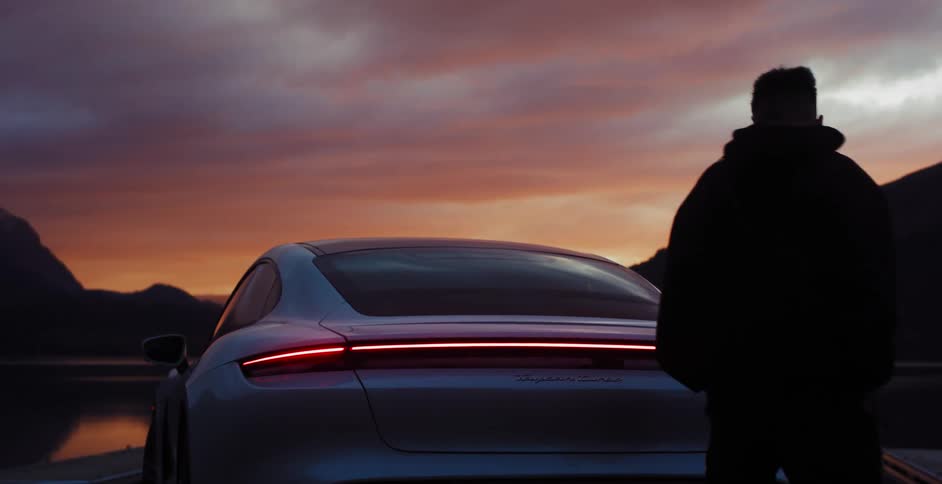 A white man walks around a parked car