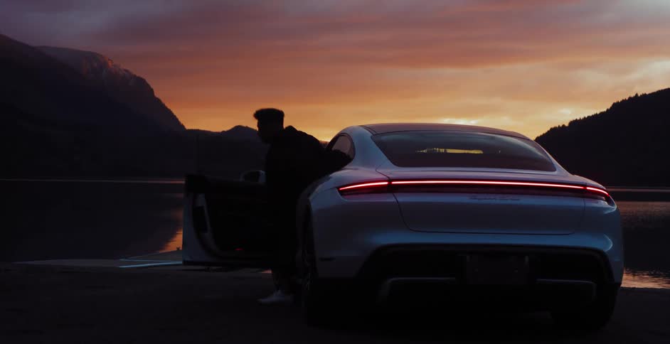 A guy is getting out of a vehicle at sunset