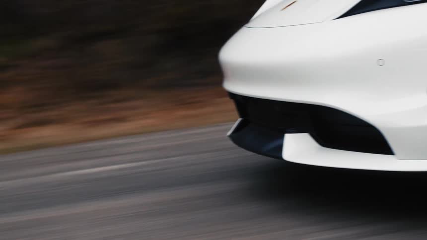 Close up of porsche taycan driving on a rural road