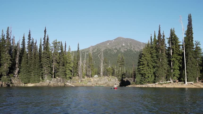 A woman kayaks away from the shore