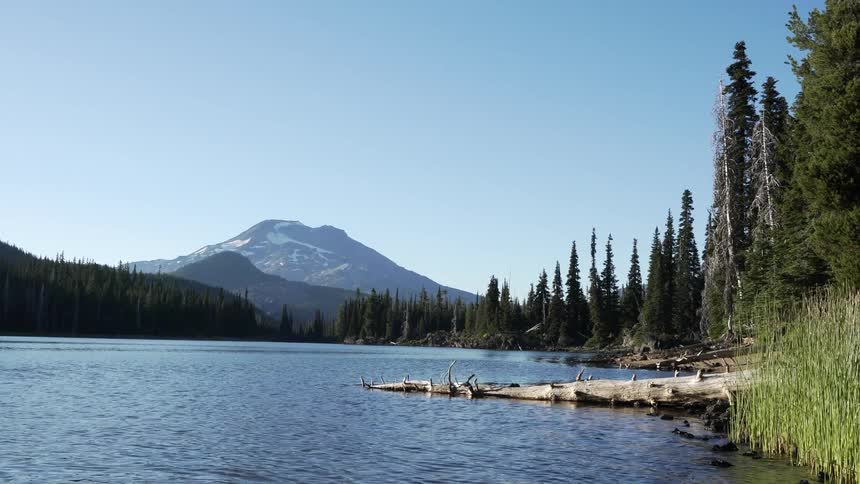 A view of a mountain in the distance surrounded by a body of water is displayed