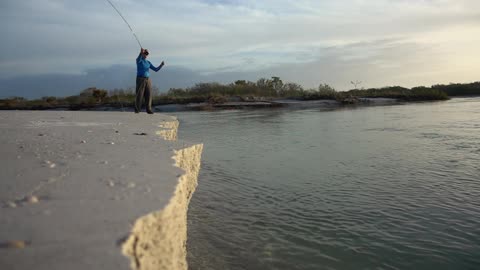 A man fishing from a seawall