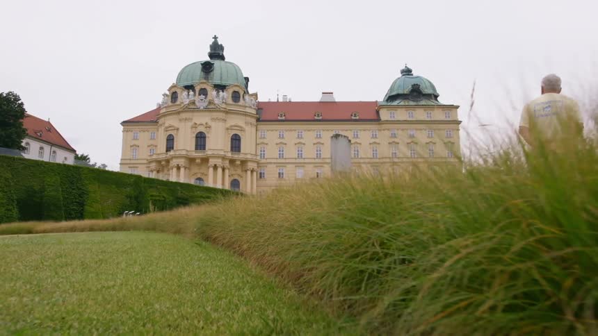 Large mansion with domes above hedge and lawn