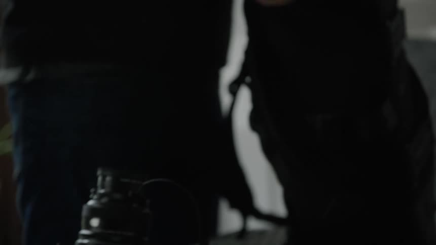 Man packing photographic equipment on backpack in his bedroom