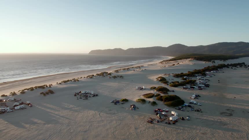 Campers parked near beach at sunset