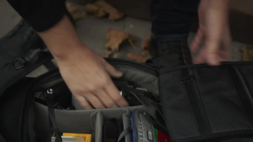 A man is putting a camera away in a bag