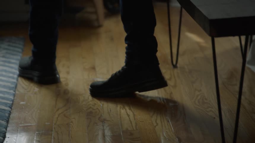 A man stands up in his bedroom and walks away