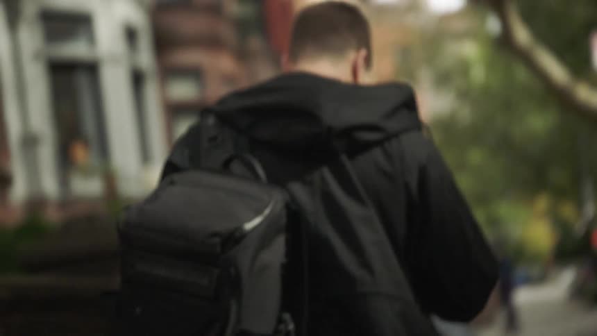 A teenager walks down a neighborhood street