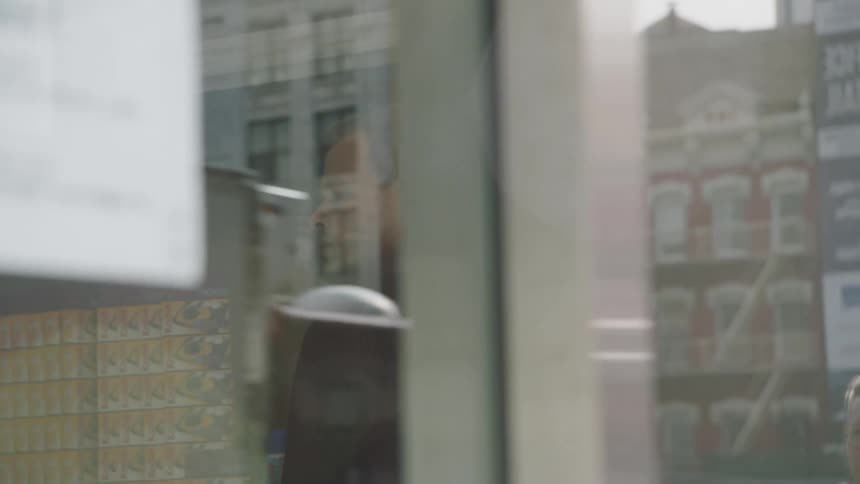 Man waiting inside a store on a busy city street