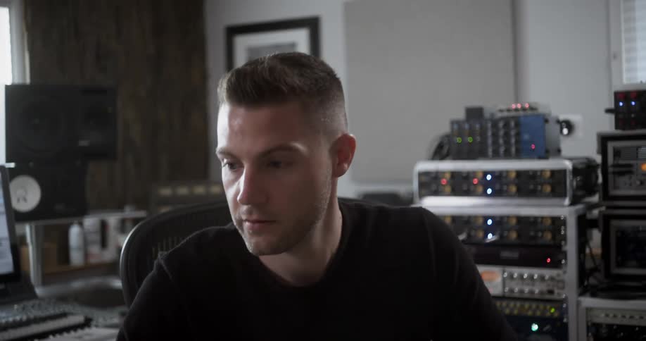 A man in a music studio using a laptop