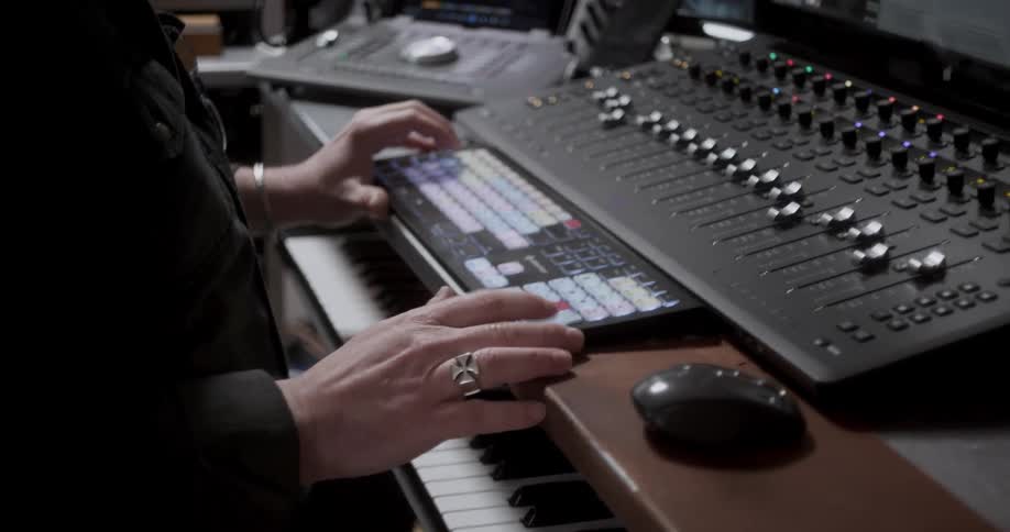 Person working on mixing equipment in recording studio