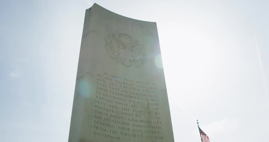An american flag flies near a monument honoring thomas jefferson