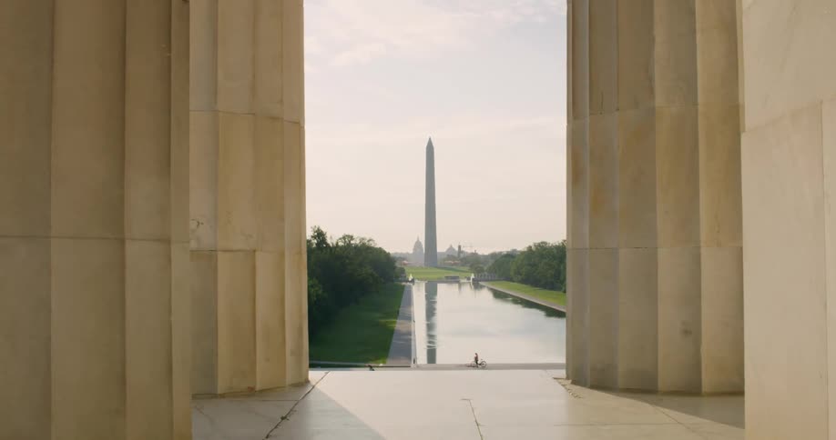 The washington monument is reflected on the surface of the water at the national mall
