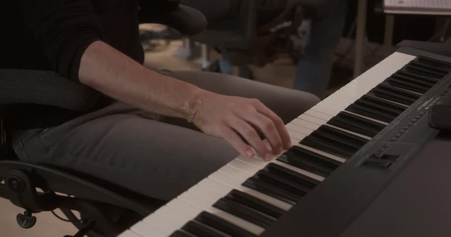 A man sits and plays the keyboard