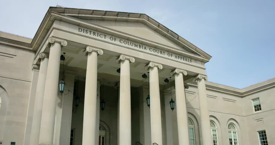 A courthouse with pillars and the sky up above