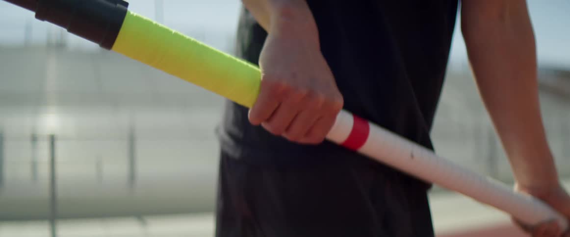 A person holding onto a pole vault