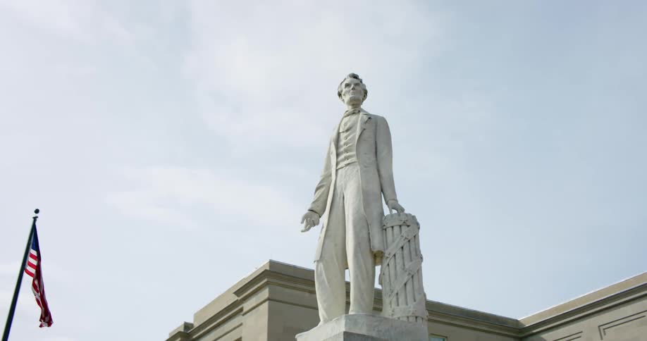 A statue of abraham lincoln outside of a government building