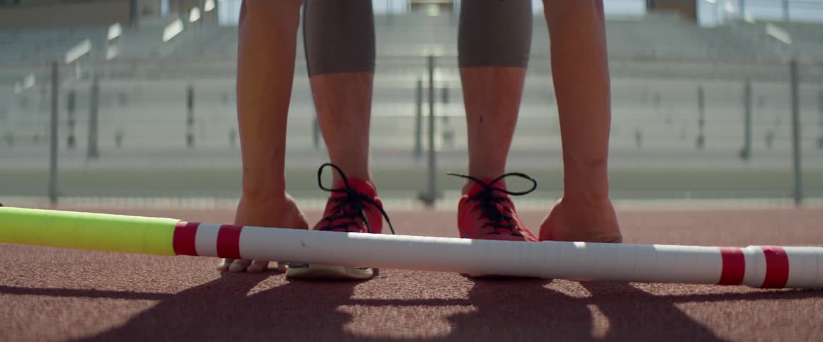 A female athlete stretches on a race track