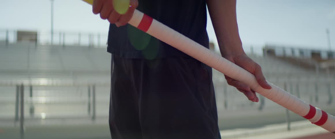 A man is exercising outdoors and holding equipment