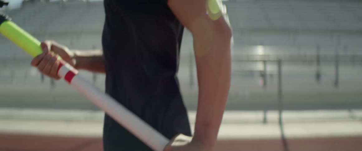 A pole vaulter runs down a track