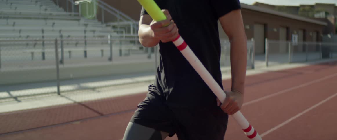 A man is running on the track with a javelin