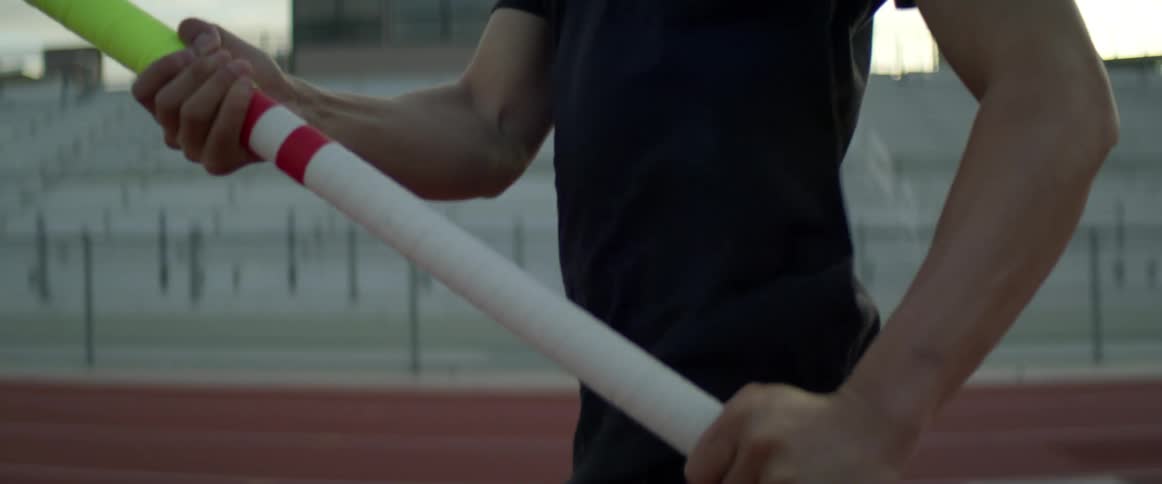 Pole vaulter runs with pole along track