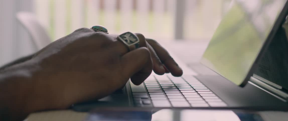 A person using a smart phone then typing on a laptop