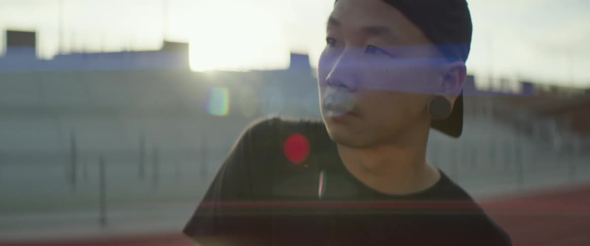 A man is standing outdoors at dusk