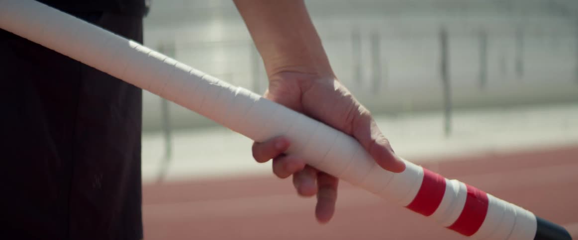 The person grips the baton