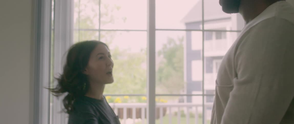 A man and woman dance and hug inside their house