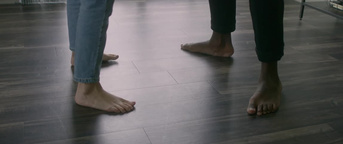 A man and woman are standing on a floor