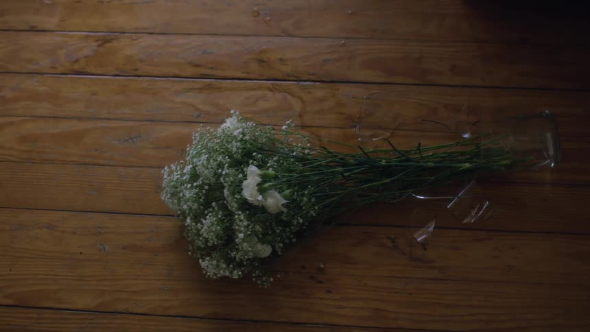 A bouquet of flowers is sitting on a wood floor