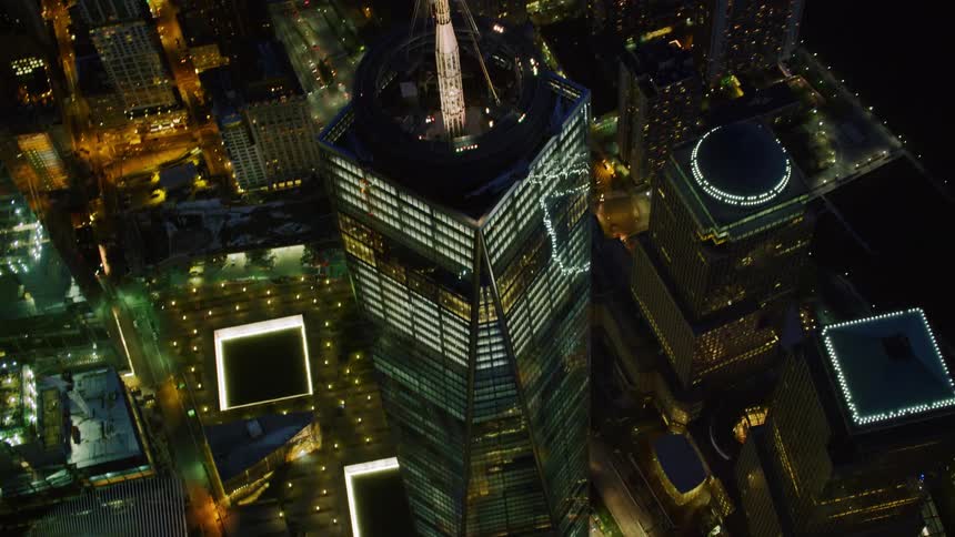 A tall skyscraper with a lit up tower on the roof