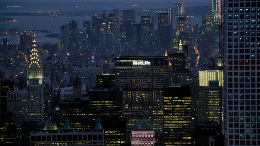 An aerial view of a downtown city at night is displayed