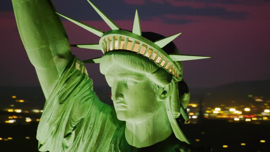 The statue of liberty lit up at night