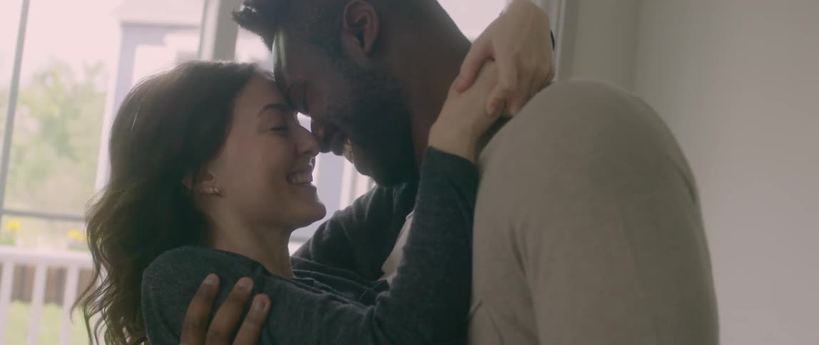 Man dips woman and lifts her up to kiss her