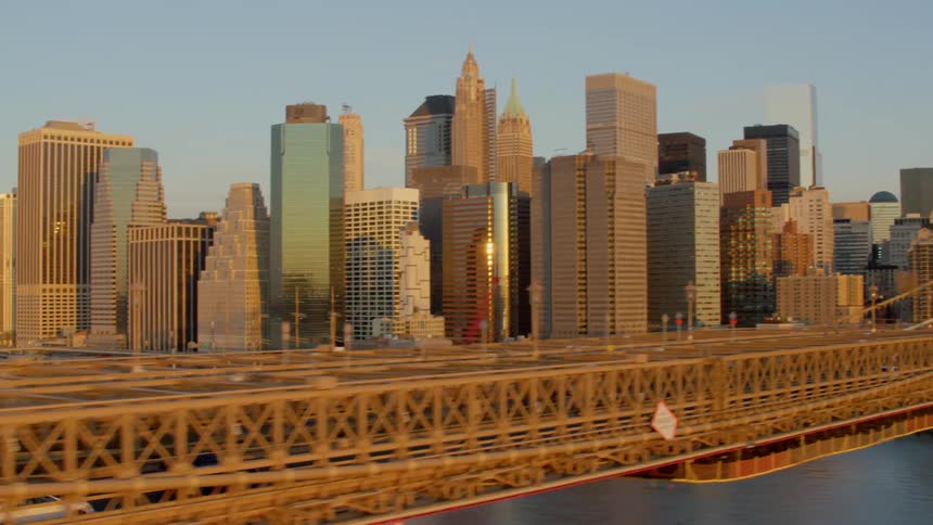 Drone footage of brooklyn bridge at dawn with manhattan skyline in background