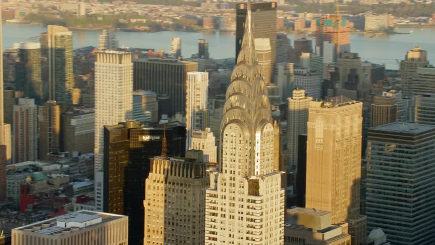 The spire of a downtown skyscraper is illuminated by the morning sun