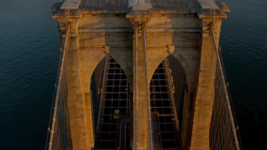 Cars travel on the bridge over the river near the city