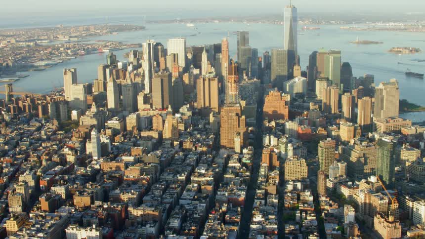 An aerial view of a downtown city is displayed by an ocean coast