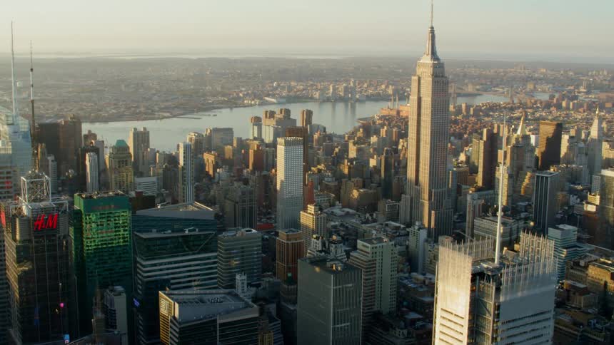 An aerial view of a downtown city is displayed at sunset