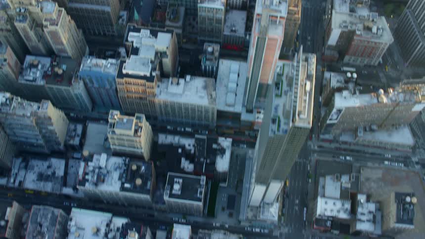 City buildings and skyscrapers sit as traffic travels on the roads