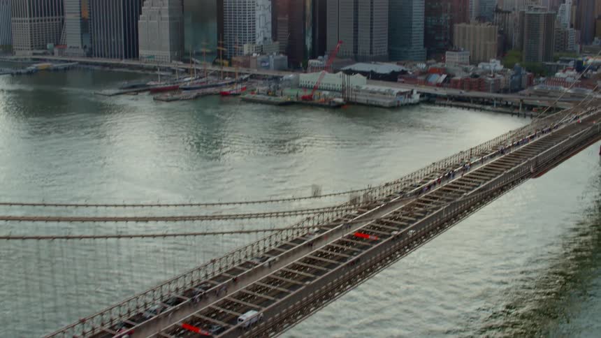 Traffic moves across a suspension bridge into the heart of a city