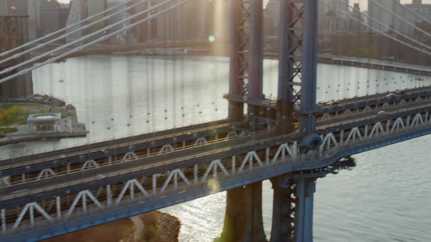 Traffic moves across a suspension bridge into a city