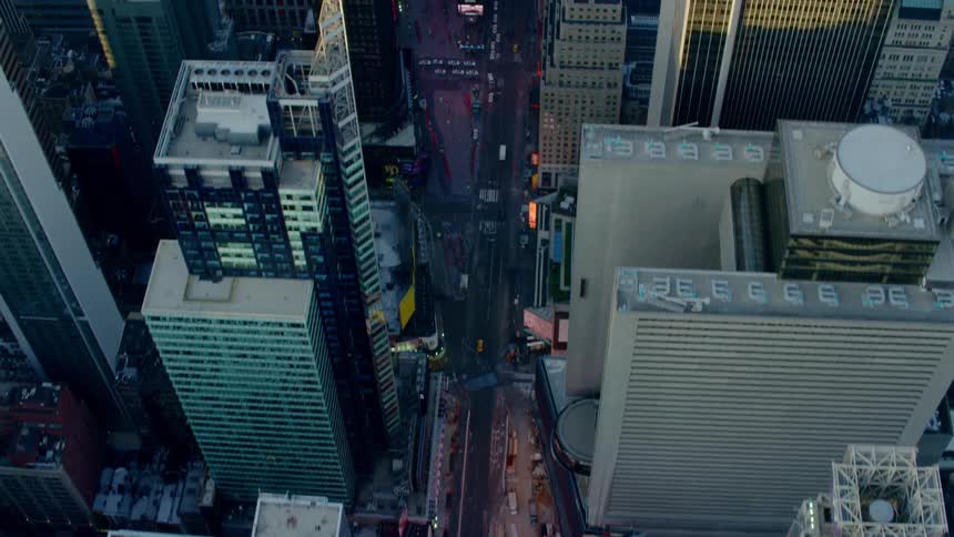 An aerial view of skyscrapers and cars driving on a city street