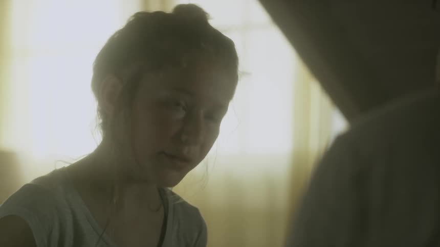 A girl is speaking to someone in a room